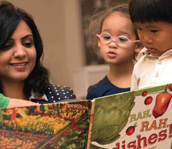 preschoolers reading book about vegetables with educator