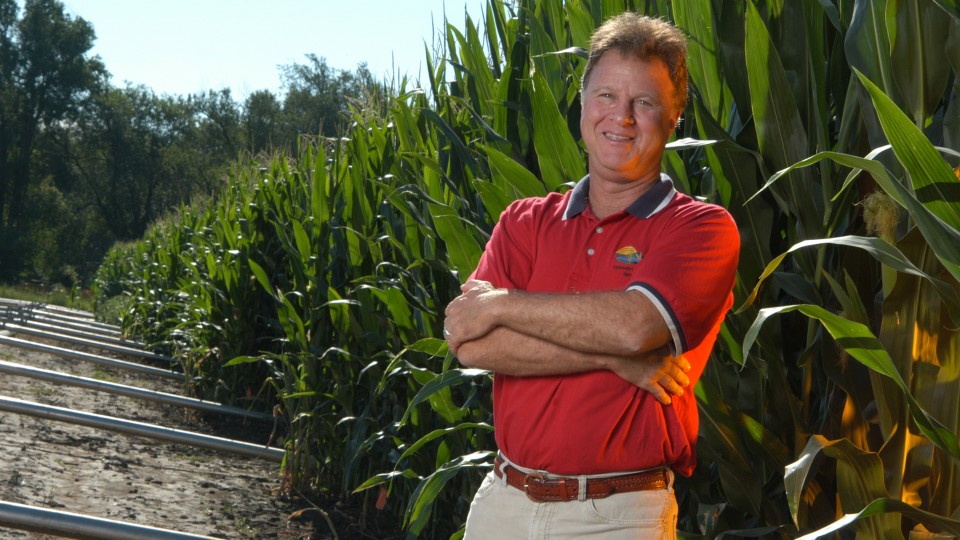 Ken Cassman, an agronomist at Nebraska, stands in a field of corn  