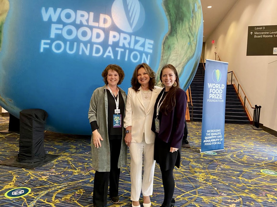 Three women stand in front of the World Food Prize globe. At left is Cohort 5 member Greetje Kranenburg of the Netherlands, 2023 World Food Prize Laureate Heidi Kühn, and Brianne Wolf CASNR Global Learning Coordinator is at right.