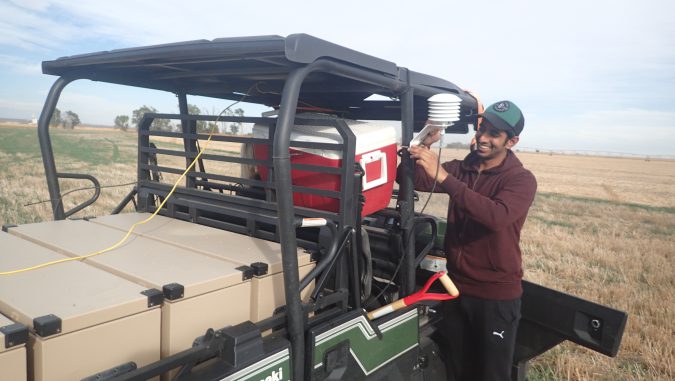 Visiting doctoral student in the field working with the cosmic ray rover in western Nebraska on an ATV outfitted with data collecting probes