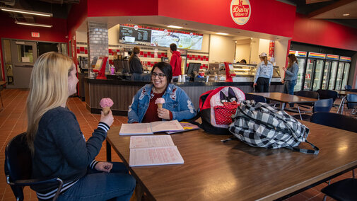 Two students eating ice cream in the Dairy Store.